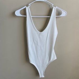 White v neck body suit, never worn, two small stains on the front barely visible